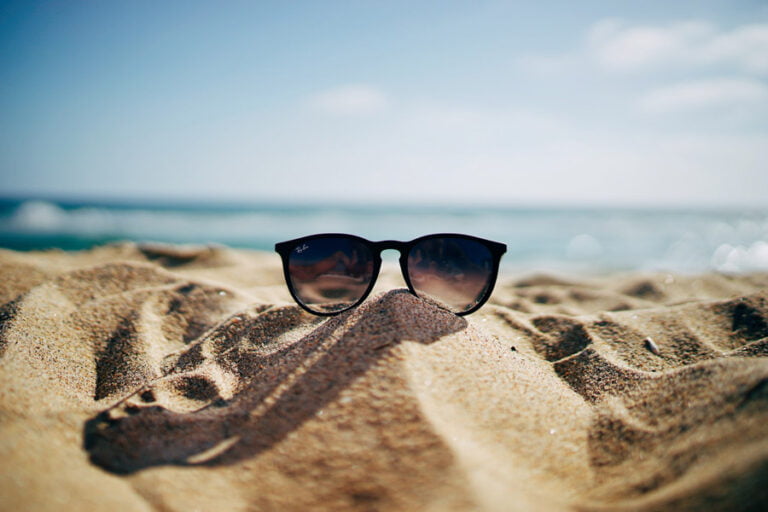 Ett par solglasögon på stranden en solig sommardag